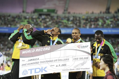 Ricardo Makyn/Staff Photographer
Jamaica's men's 4x100 quartet (from left) Usain Bolt, Yohan Blake, Michael Frater and Nesta Carter display their bonus cheque for establishing a new world record, in the 4x100 metres final at the Daegu Stadium, during the World Athletics Championships in Daegu, South Korea, yesterday. The Jamaicans clocked 37.04 seconds to erase their own mark of 37.10.


 September4, 2011