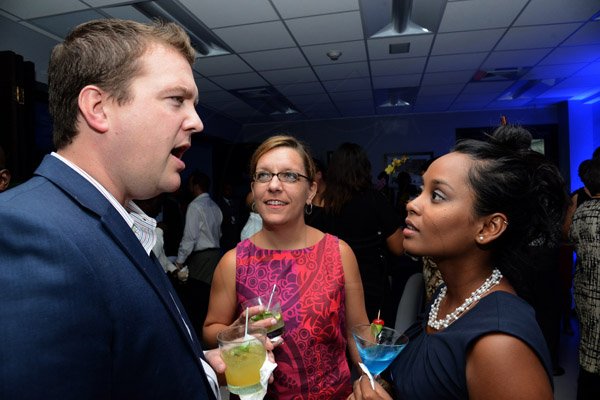 Winston Sill/Freelance Photographer
PUBLIC AFFAIRS and BUSINESS DESKS:----- Ryan Hanlon of the US Embassy chats with Sharon Gulick (centre) and Erlene Kowlessar as J Wray and Nephew Limited, a Gruppo Campari Company, presented the Official Opening of the JWN Corporate Office,  at Dominica Drive, New Kingston on Thursday night April 10, 2014.