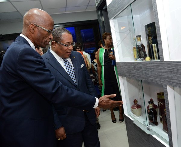 Winston Sill/Freelance Photographer
PUBLIC AFFAIRS and BUSINESS DESKS:----- J Wray and Nephew Limited, a Gruppo Campari Company present the Official Opening of the JWN Corporate Office,  at Dominica Drive, New Kingston on Thursday night April 10, 2014. Here are Clement Lawrence (left), Managing Director, J Wray and Nephew shows Industry Minister Anthony Hylton some of the items available in the Specialty Store of the new corporate offices of J Wray and Nephew.
