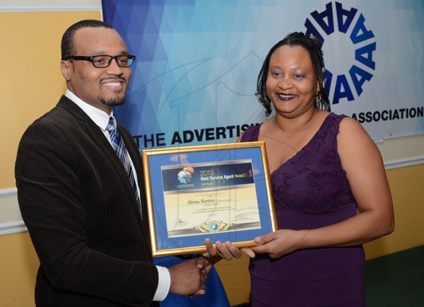 Rudolph Brown/Photographer
Arnold 'JJ' Foote, (left) President of Advertising Agencies Association of Jamaica (AAAJ) presents the winning trophy to The Gleaner's  Managing Director Christopher Barnes and Advertising and Operations Manager Nordia Craig at (AAAJ) Media Awards luncheon at the Terra Nova Hotel in Kingston on Wednesday, October 22,2014