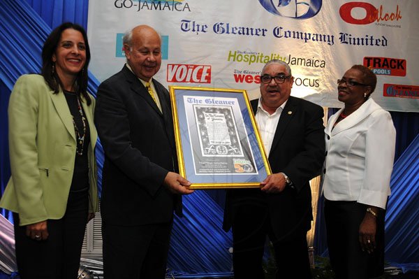 Gladstone Taylor / Photographer

Chairman of The Gleaner Oliver Clarke (second left) and Business Development and Marketing Manager Karin Cooper (right) present a Jamaica 50 Award to Robert MacMillan of MacMillan Advertising. Looking on is Zein Issa-Nakash, representing the client (House of Issa). MacMillan Advertising was one of two to have an ad on the Gleaner front page on Independence Day in 1962.
 Jamaica Gleaner hosts advertisers appreciation and agency awards luncheion held at the jamaica Pegasus, kingston