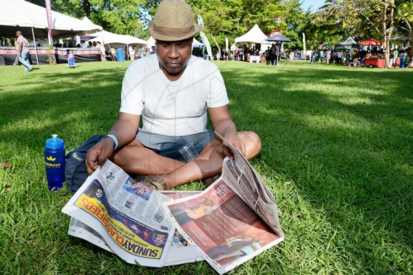Rudolph Brown/Photographer
Gamil Coke enjoys his newspaper of choice, the Sunday Gleaner ofcourse, after making his rounds to all the tents at the All Jamaica Grill off on Sunday.