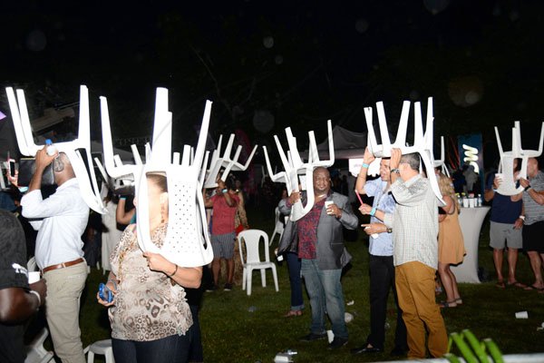 Jermaine Barnaby<\n>Photographer<\n><\n>Rain did not stop the party, as plastic chairs were used as makeshift umbrellas. *** Local Caption *** @Normal:Rain did not stop the party as plastic chairs were used as makeshift umbrellas.