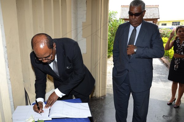 Rudolph Brown/Photographer
Edmund Bartlett, (left) Minister of Tourism and John Lynch, Director and Chairman, Jamaica Tourist Board signs the condolence book at the funeral service for the late Anthony Abrahams at St. Andrew Parish Church on Wednesday, August 17-2011