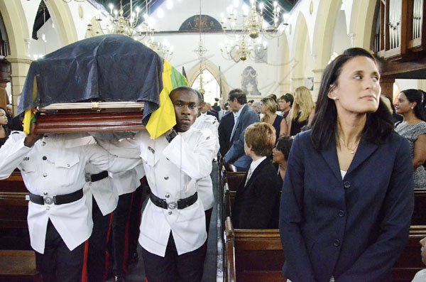 Rudolph Brown/Photographer
Tara Abrahams-Clivio (right), daughter of the late Anthony Abrahams, stands by as her father's coffin is taken from the St Andrew Parish Church yesterday.