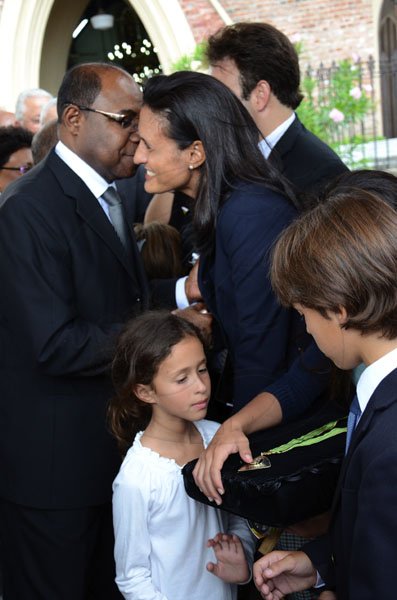 Rudolph Brown/Photographer
Edmund Bartlett, Minister of Tourism greets Tara Abrahams-Clivio daughter, while the grandchildren Chamotte and Max Clivio (right) looking at their grandfather medal of Honour at the funeral service for the late Anthony Abrahams at St. Andrew Parish Church on Wednesday, August 17-2011