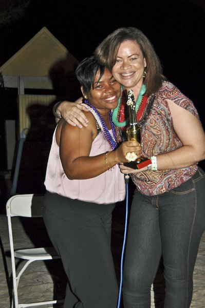 Janet Silvera
Digicel's Olive Lawson (right) hugs guest of honour former co-worker Audi Allen-Lawson after presenting her with one of 10 awards at farewell party at the Aquasol Theme Park, Montego Bay, last Friday night in Montego Bay