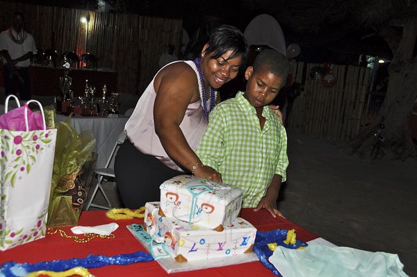 Janet Silvera Photo
 
 Audi Allen-Lawson cuts her Louis Vuitton cake with son Kyle Bowen at a farewell party in her honour at the Aquasol Theme Park, Montego Bay last Friday night