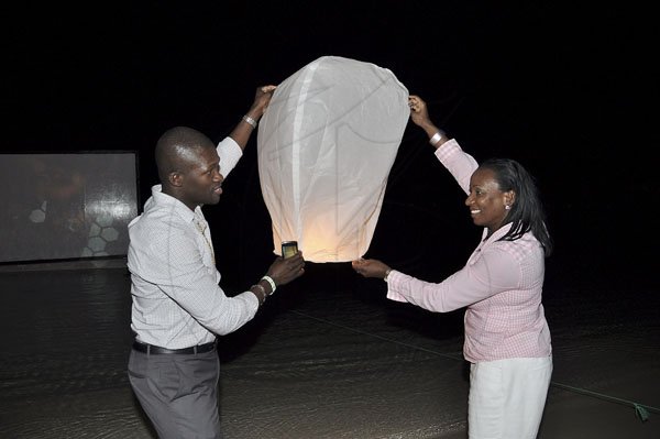 Janet Silvera
Digicel's Tafari Ewers and Joy Clark getting ready to release the Thai themed biodegradable floating lantern in celebration of their former colleague, Audi Allen-Lawson's years of service to the company at a farewell party in her honour at the Aquasol Theme Park