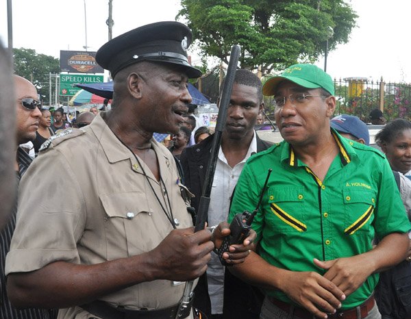 Jermaine Barnaby/Photographer
Deputy Superintendent Robblin Wedderburn (left) points makes some reference of the illegalness of opposition leader Andrew Holness staging a march from Half Way Tree towards the NWA office along Maxfield Avenue as members of the JLP held a protest against bus fare increase in Half way Tree on Monday August 25, 2014.