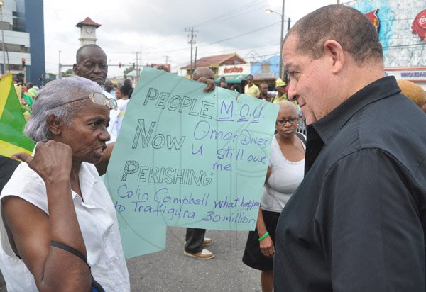 Jermaine Barnaby/Photographer
Jacqueline Hutchinson (left) tells her plea to Audley Shaw during a protest against bus fare increase in Half way Tree on Monday August 25, 2014.