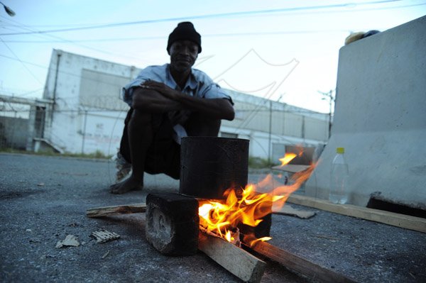 Norman Grindley/Chief Photographer
(Capturing Kingston) A man cook porage by the road side in downtown Kingston November 24,2012.