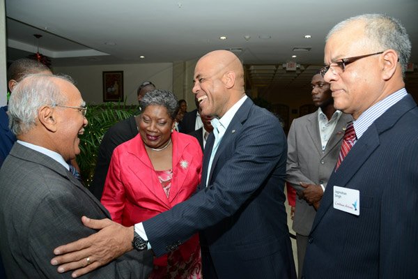 Rudolph Brown/Photographer
Haitian President H.E. Michel Martelly, (second right) greets Dennis Lolar,(left) Board Director, Carol Guntley, director general in the Ministry of Tourism and Jagmohan Singh, (right) Acting CEO of Caribbean Airline  at the Caribbean Airlines awards and Corporate Event at the Jamaica Pegasus Hotel on Friday, November 15, 2013