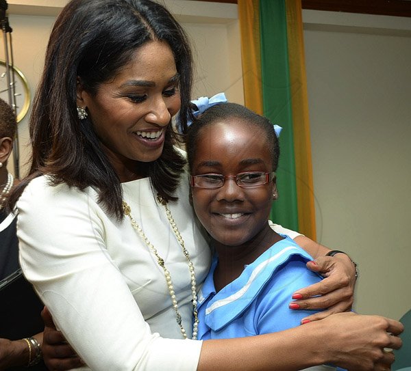 Ian Allen/Photographer
Nadiea Patterson right a student of Davis Primary School in St.Catherine gets a hug fromLisa Hanna, Minister of Youth and Culture after sung a song at the Media Launch of Child Month 2013 which was held at Grace Kennedy Offices in Down Town Kingston on Wednesday.
