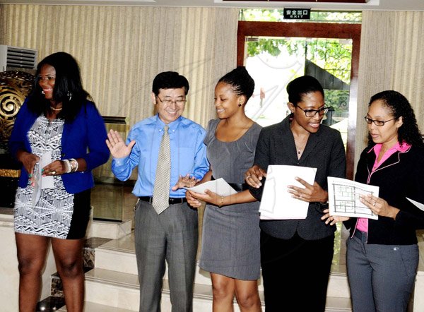 Winston Sill/Freelance Photographer
Xia Guoshun (second left), political counsellor at the Chinese Embassy in Kingston, speaks with (from left) students Sanya Smith; Suzan Dabney; Georgia Simon; and Kimberly Chin during yesterday's awarding ceremony for seven Jamaican students who received  Chinese government scholarships at the Ambassador's St Andrew residence.