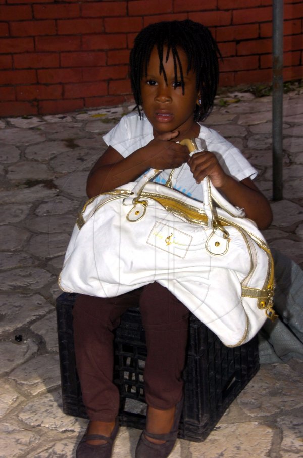 Norman Grindley/Chief Photographer
A little girl by her parents stall in downtown Kingston December 15, 2010.