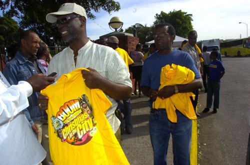 Norman Grindley/Chief Photographer
Kingston Mayor Desmond McKenzie hold a shirt that is being handed out to vendors who participate in Christmas in the city, downtown comes alive 'Shop Till U Drop'  in downtown Kingston December 15, 2010.