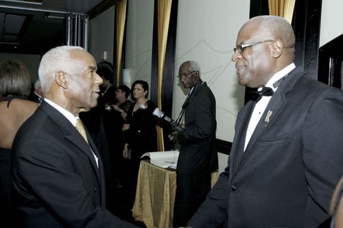 Contributed
Chairman of the Jamaica Civil Aviation Authority  board Y.P.  Seaton (left), greets Lt. Col. Oscar Derby , director general of the JCAA.

******************************************************************, at the Aviation Industry Awards Dinner