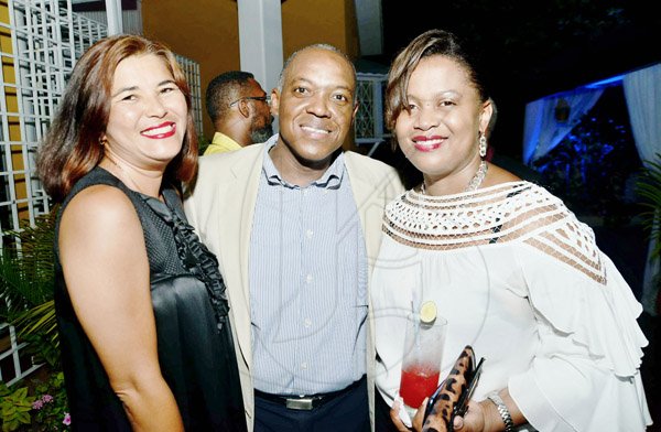 Rudolph Brown/Photographer

Heston Hutton, managing director of CSS, a subsidiary of JCCUL is beaming from ear to ear next to his lovely wife Tashia (right) and friend Jacque Chance-Bird (left)  at the JCCUL cocktail reception in honour its new mobile payment system on Friday.