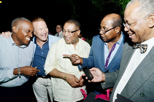 Rudolph Brown/Photographer
Heston Hutton,(left) managing director of CSS  looks at the new mobile E-payment on the phone whil still sharing in the humorous moment with (from right) Professor Winston Davis, Edmund Bartlett, Minister Anthony Hylton and Ron McKay.