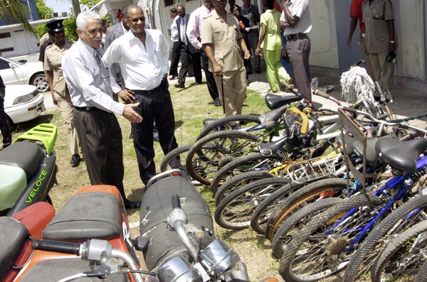 Norman Grindley /Deputy Chief Photographer 
Senator Trevor MacMillan (left) minister of National security and Senator Arthur Williams minister of state in the ministry of national security examined bicycles and motor bikes that was seized by police during a tour at 100 man police station. The minister and other officials toured sevral stations in St. Catherine and Clarendon yesterday