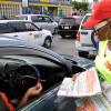 Jermaine Barnaby/Photographer
2009 Digicel Rising Stars winner, Shuga (right) tries to get a sale from a motorist in Half Way Tree during The Gleaner's corporate street sale day on Monday September 8, 2014.
