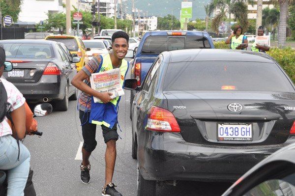 Jermaine Barnaby/Photographer
Digicel 2010 Rising Star winner Dalton Harris moves in traffic in a bid to sell copies of  The Gleaner newspaper during the company's corporate street sale day on Monday September 8, 2014.