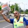 Jermaine Barnaby/Photographer
Managing director of The Gleaner Christopher Barnes holds aloft a copy of the newspaper in a bid to sell oncoming motorist during his company's corporate street sale day on Monday September 8, 2014 along Kings House road.