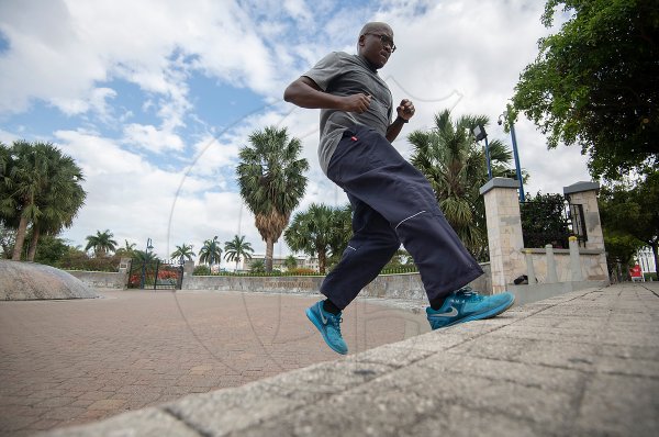 50 year old Wade Dallas exercises outside the gates of Emancipation Park in St Andrew on Saturday Morning March 21, 2020. Parks were ordered closed as the government continues its efforts to stop the spread of COVID-19.