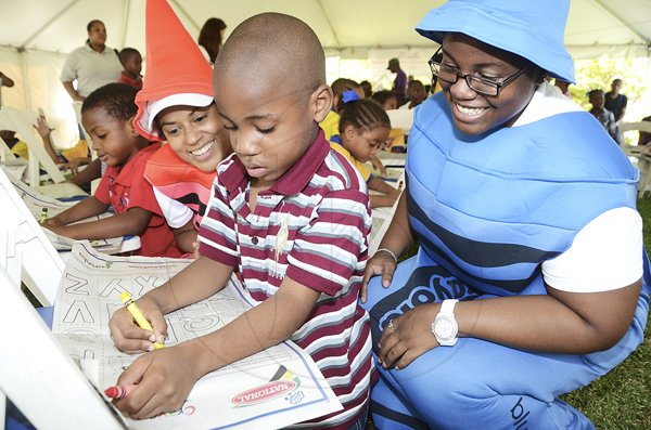 Rudolph Brown/Photographer
Daniel King, colour the Gleaner colouring page while looking from left are Deika Morrison and Kerri-Ann Allen at the Family Fun Day at the Do Good Jamaica, Kingston Book Festival at Emancipation Park on Saturday March 17-2012