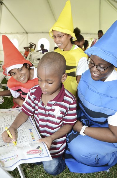 Rudolph Brown/Photographer
Daniel King, colour the Gleaner colouring page while looking from left are Deika Morrison, Garielle Miller and Kerri-Ann Allen at the Family Fun Day at the Do Good Jamaica, Kingston Book Festival at Emancipation Park on Saturday March 17-2012