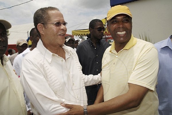 Leon Mitchell (right), Assistant General Manager, Marketing, and Promotions JNBS, greets Prime Minister the Honourable Bruce Golding as he embarks on a tour of the JN House at the 2010 Denbigh Agricultural and Industrial Show on Monday, August 2, 2010.