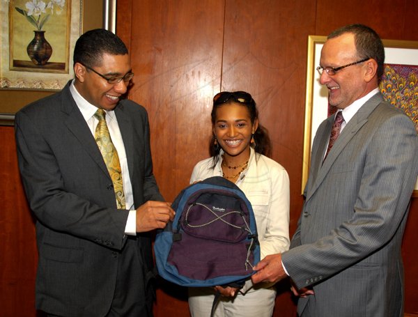 JIS Photo                                                                                                                                                                                                                                                         Minister of Education, Hon Andrew Holness (left)  and  Minister of State in the Ministry of Education, Hon. Gregory Mair (right), examine one of the backpacks that will be donated to  Denbigh High School, by  Project Co-ordinator of  Lili?s Backpack, Miss Lili Henry (centre), at the Ministry on June 30.