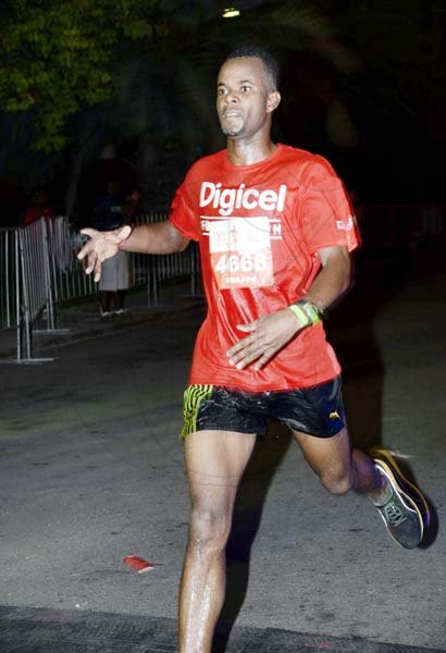 Winston Sill/Freelance Photographer
Damion Bent crosses the line in 15:11 minutes to win the overall men's run section of Saturday's Digicel Foundation 5K Night Run/Walk, held at the Waterfront, Downtown, Kingston.