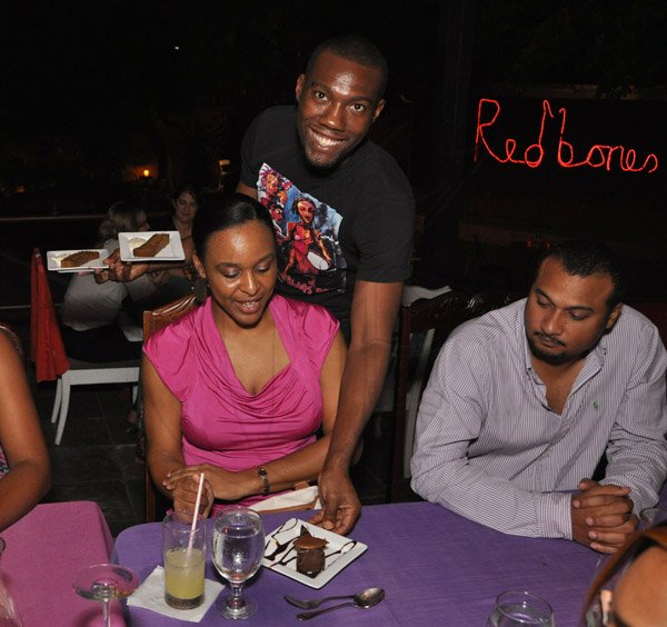 Jermaine Barnaby/Photographer
Kalia- Gaye Dunbar (left) and husband Richard Dunbar being attended to by waiter Leonard Wilson during The Gleaner's Pre-Restaurant Week Dinner Promotions 2013 with Karin Cooper and guests at  Red Bones on Tuesday, November 5, 2013.