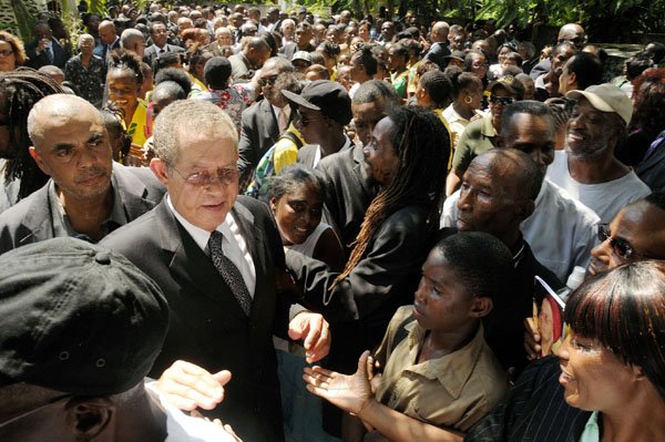 Gladstone Taylor / Photographer
Prime Minister Bruce Golding is flocked by hundreds of mourners during yesterday's funeral for his mother.