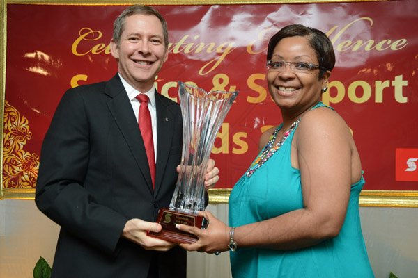 Rudolph Brown/Photographer
Bruce Bowen, President and CEO, Scotiabank presents Nardia Gordon Somers with the Top team of the Year, Support trophy at the Scotiabank Group Celebrating Excellence Service and Support awards ceremony at Knutsford Court Hotel in Kingston on Saturday, May 18, 2013