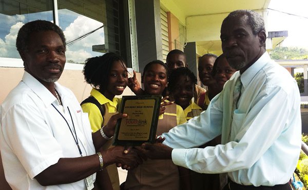 Contributed 
  Lambert Robinson (right), the principal of Anchovy High School, accepts The Gleaner's Youth Link plague from Adrian Frater, the New Editor at The Gleaner's Western Bureau. A group of obviously happy students share the experience.