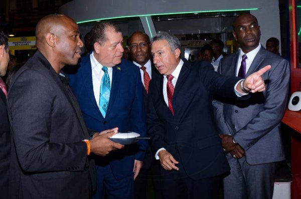 Shorn Hector/Photographer  Brain Bennette-Easy General Manger Digicel Jamaica (left) ishowcasing the lates in technolofy that digicel has to over to The Hon. Audley Shaw and Metry Seaga at Expo Jamaica 2018 Opening Ceremony at the National Indoor Sports Complex on April 19 2018