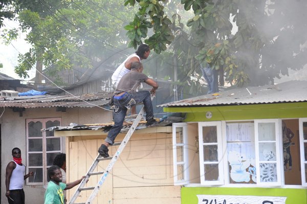Norman Grindley/Chief Photographer
A major fire this afternoon destroyed several houses on Regent Street in downtown Kingston. Three fire units and a water truck arrived on the scene as fire personnel tried to contain the blaze September 26, 2012.