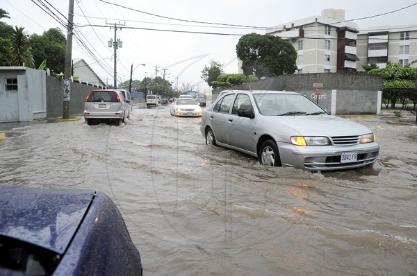 Rudolph Brown/Photographer
Motorists drive through water on Trafalgar Road after heavy rain fall on Wednesday, September 29-2010