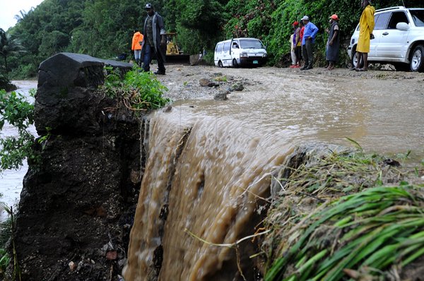 Rudolph Brown/Photographer
Workmen clear landslides on Castleton main road after block by heavy rain fall in St. Mary on Wednesday, September 29-2010