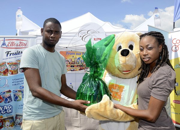 Gladstone Taylor / Photographer

Rohan Cummings (left) accepts his prize from Deandrea Matherson (Promotion Supervisor, Chas Ramson) for first place in the diaper changing competition
the shoppers fair food month promotion in Harbour View on saturday