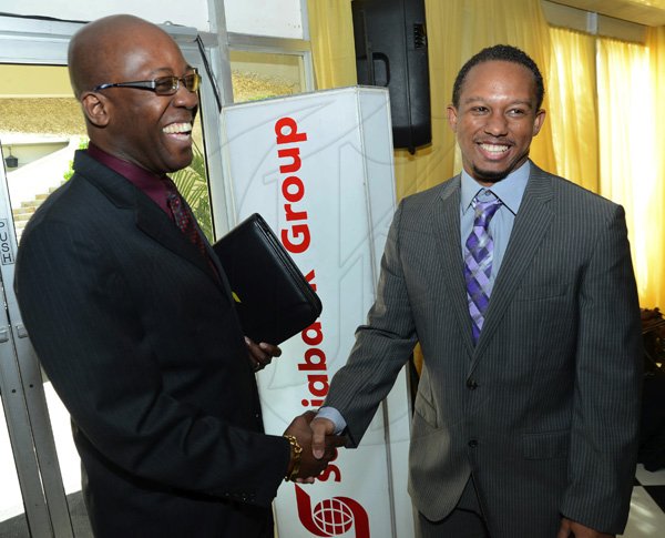 Rudolph Brown/Photographer
Hugh Reid, president of Scotia Insurance greets Olympian Michael Frater at the Scotiabank Golden Cleats Awards Luncheon at Venetian Suite, Terra Nova Hotel on Tuesday, January 8, 2013.