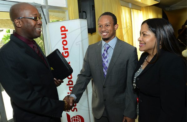 Rudolph Brown/Photographer
Hugh Reid, president of Scotia Insurance and Suzette Smellie-Tomlinson, Director, Marketing Programmes, Scotia greets Olympian Michael Frater at the Scotiabank Golden Cleats Awards Luncheon at Venetian Suite, Terra Nova Hotel on Tuesday, January 8, 2013.