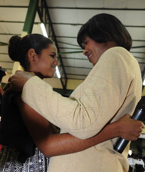 Ricardo Makyn/Staff Photographer
Tori Haber a member of the Church receives a embrace after  making a presentation to the    Prime Minister the Most Hon.Portia Simpson Miller  at the Portmore New Testament Church of God as She and Ministers and Members of Parliament attended a Church service.