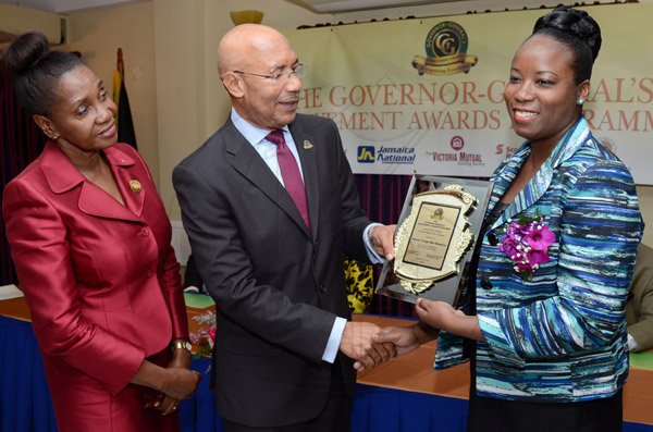 Rudolph Brown/Photographer
GG presents award toTameka Hue-Hamilton while Custos of St Thomas, Hon. Marcia Bennett looks on at the Governor General’s Achievement Award for the County of Surrey presentation Ceremony for recipients on Thursday, September 25, 2014