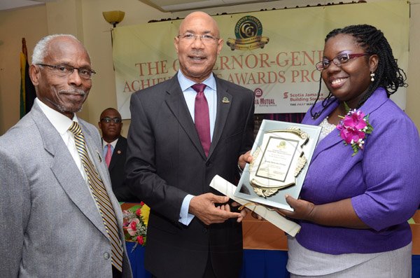 Rudolph Brown/Photographer
GG presents award to Kemoy Phillips while Custos of Portland, Hon. Lincoln Thaxter looks on at the Governor General’s Achievement Award for the County of Surrey presentation Ceremony for recipients on Thursday, September 25, 2014
