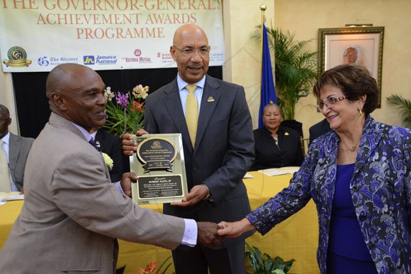 Rudolph Brown/Photographer
Governor General Sir Patrick Allen (centre) presents Robert Allen a Jamaica 50th Jubilee Award of Excellence while the honouree receives congratulations from Custos of St Catherine Rev Sophia Azan. Governor General's Achievemnet Awards at Kings House on Tuesday, November 13, 2012