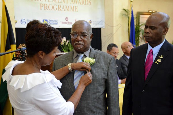 Rudolph Brown/Photographer
Lady Allen presents Albert Gray (centre) with his Governor General's Achievement Award while Custos of Kingston Steadman Fuller looks on.
 at Kings House on Tuesday, November 13, 2012